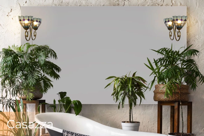 A stylish bathroom with a tub, beautiful plants, and a Casazza lamp mirror.