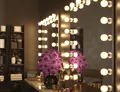 Preview of Hollywood mirror with purple flowers and makeup accessories on a countertop table.