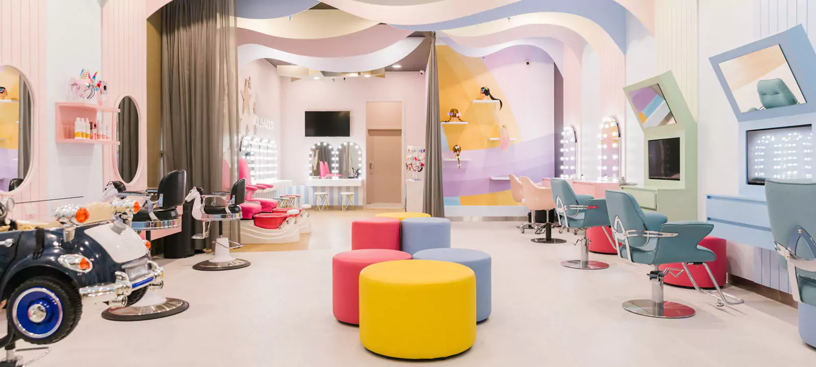 A sleek and vibrant salon with colorful chairs and arch-shaped Hollywood mirrors.