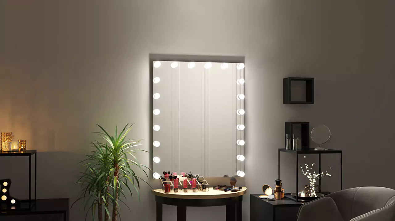 Hollywood mirror mounted on the wall with make-up accessories on a vanity table.