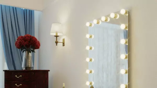 Hollywood mirror with a flower vase on the top of the file cabinet on the side and a wall lamp.