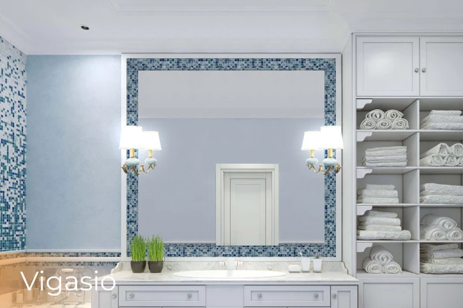 A bathroom with an elegant sink and a vigasio in a lighted mirror set on a blue mosaic wall.